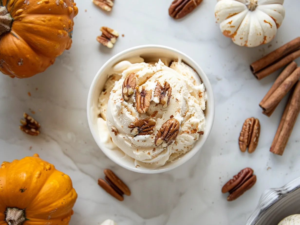 Ingredients for making Pumpkin Pecan Frozen Yogurt, including Greek yogurt, pumpkin puree, maple syrup, pecans, pumpkin pie spice, vanilla extract, and salt.
